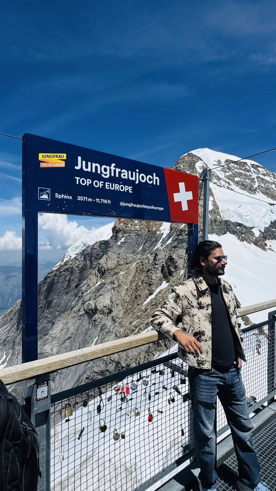 Gautam Kumawat beside the Jungfraujoch 'Top of Europe' sign, snow and rock behind him