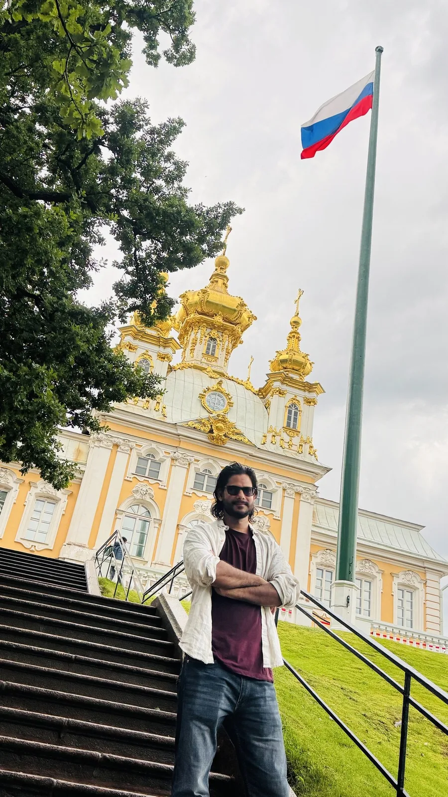 Gautam Kumawat on the steps of a gilded baroque palace, a flag flying from its roof